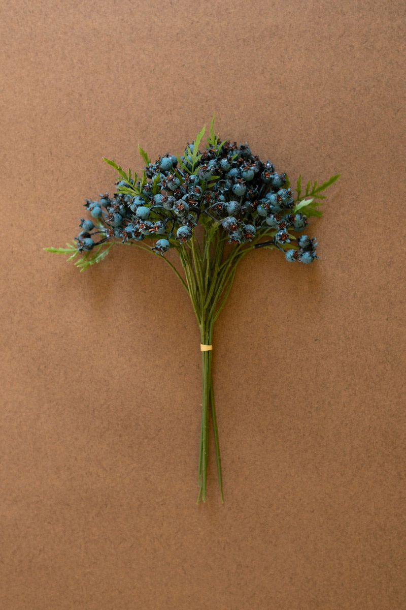 Bouquet of blue flowers with green stems on a brown background