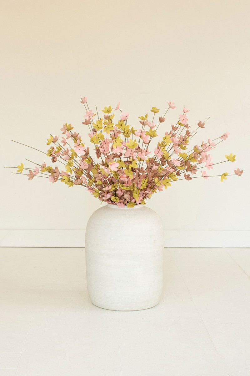 White vase with pink and yellow flowers on a light beige background