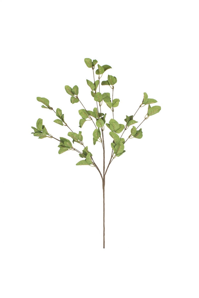Artificial green leaf branch on a white background