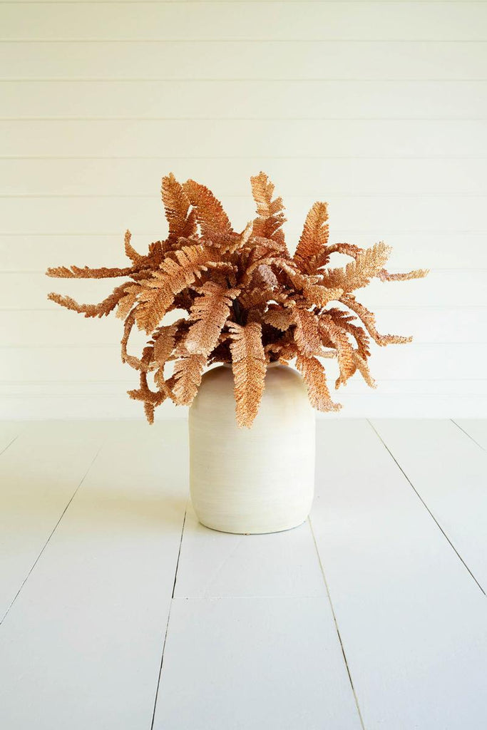artificial plant with long rust colored leaves made with latex rubber - shown in white pot