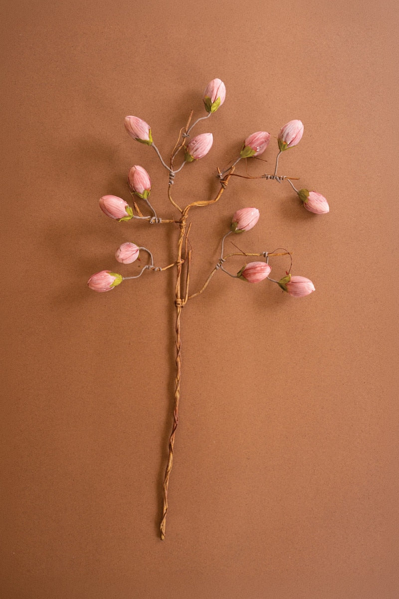 Decorative hairpin with pink floral tips on a brown background