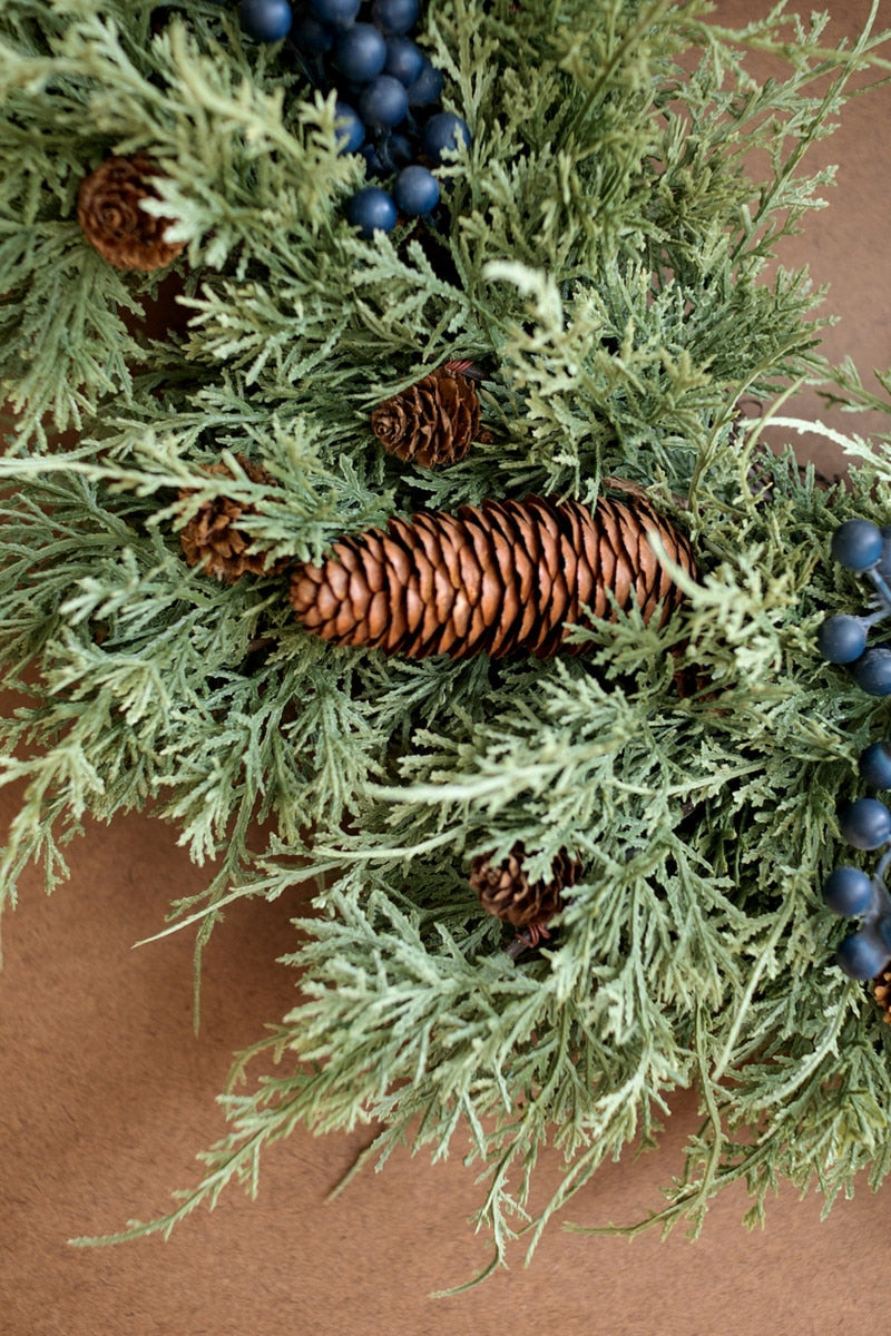 close-up view of evergreen wreath, pine cones and berries