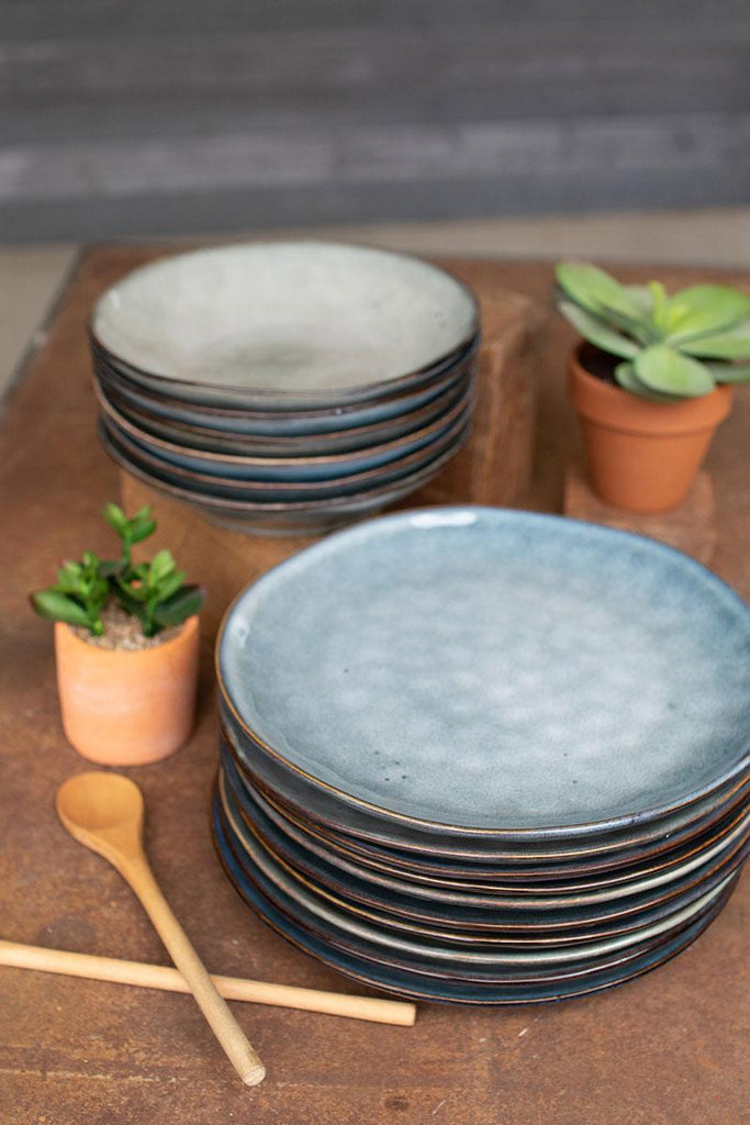 two stacks of ceramic plates, one in oatmeal the other in faded blue color on top of wood table