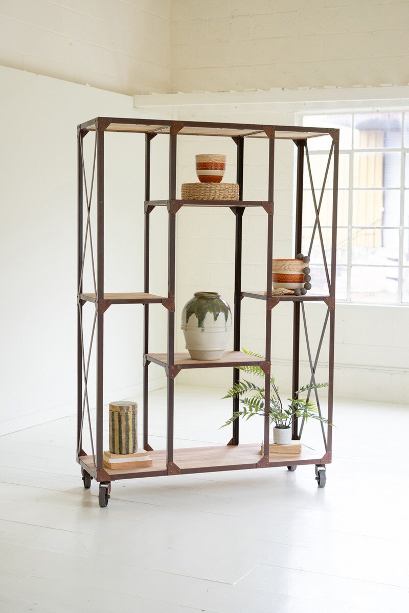 Industrial-style metal and wood bookshelf with decorative items in a bright room.