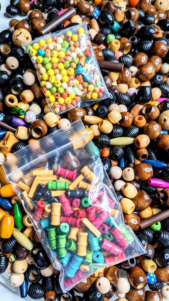 collection of colorful wood beads oval, rectangle, round, wooden sticks - close up - 2 pouches of extra beads