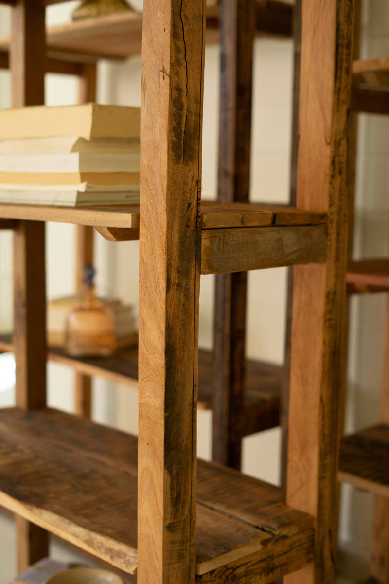 Wooden bookshelf with books and a bottle on shelves - close-up of middle shelf from right angle