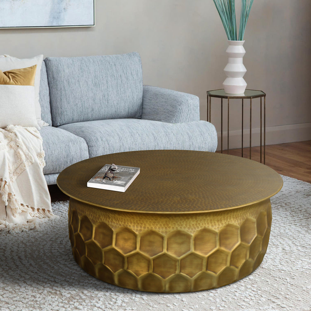 round hammered aluminum coffee table with brass finish in living room setting