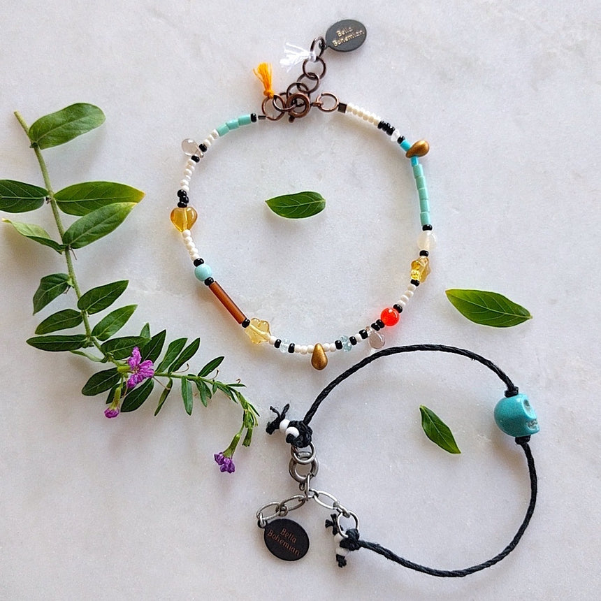 set of bracelets, one with black cotton thread, the other with multicolored seed and glass beads