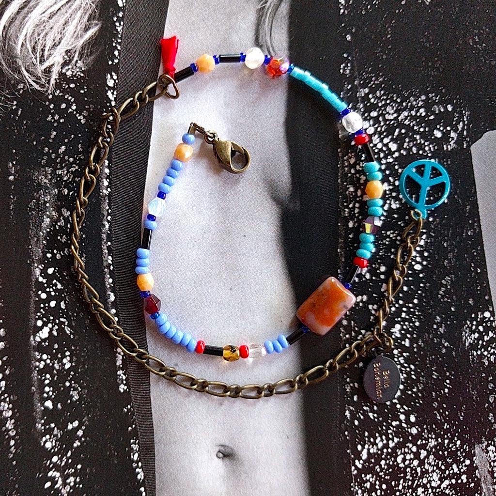 handmade friendship bracelets with colors of blue red amber and clear beads on alternate background