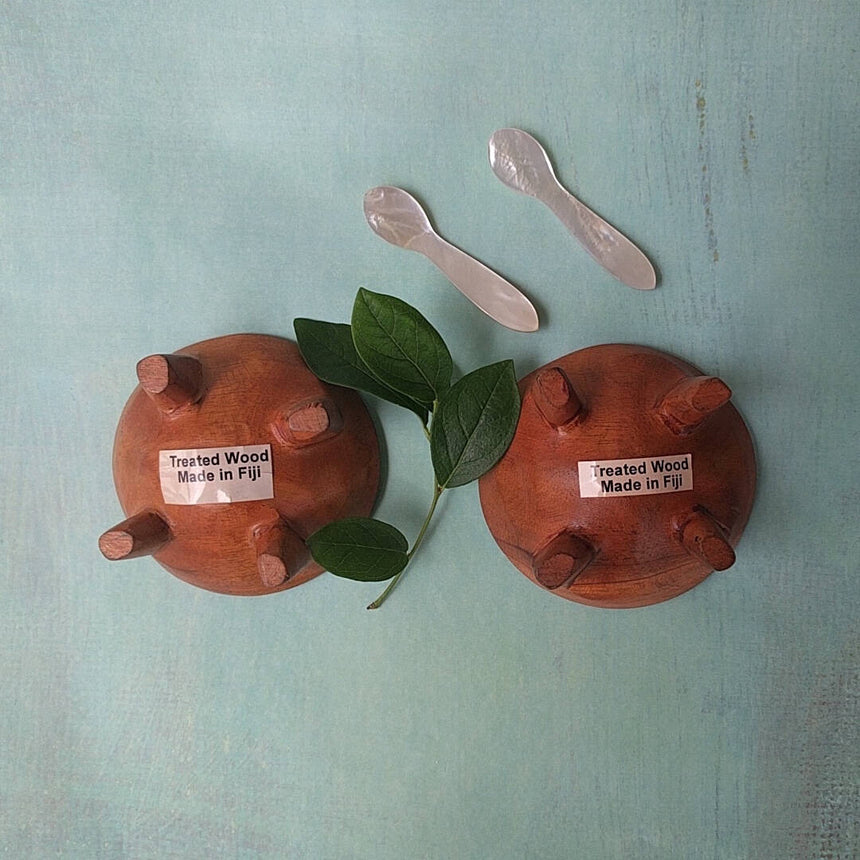 Fijian light wood salt and pepper cellars shown with two mother-of-pearl spoons - bottom view