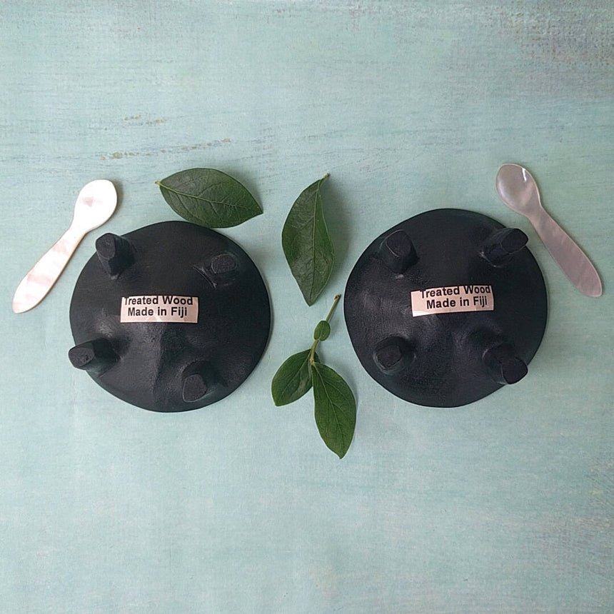 Fijian dark wood salt and pepper cellars shown with two mother-of-pearl spoons - bottom view