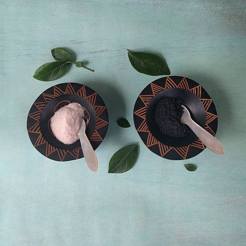 hand carved Fijian dark wood salt and pepper cellars shown with salt and pepper - top view