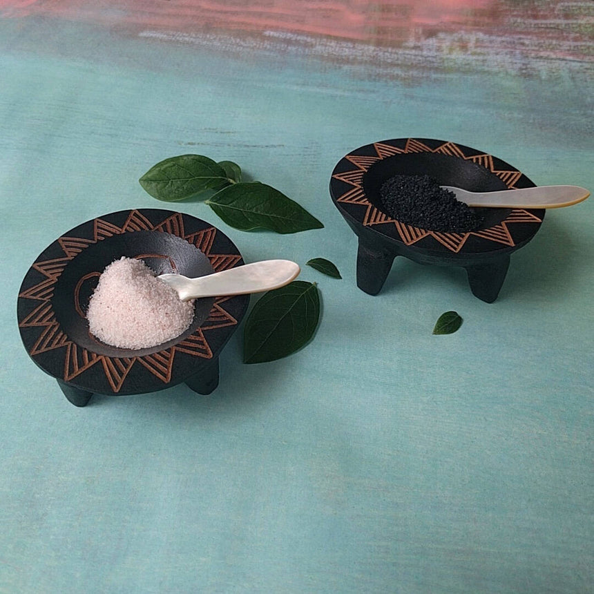 hand carved Fijian dark wood salt and pepper cellars shown with salt and pepper - side view