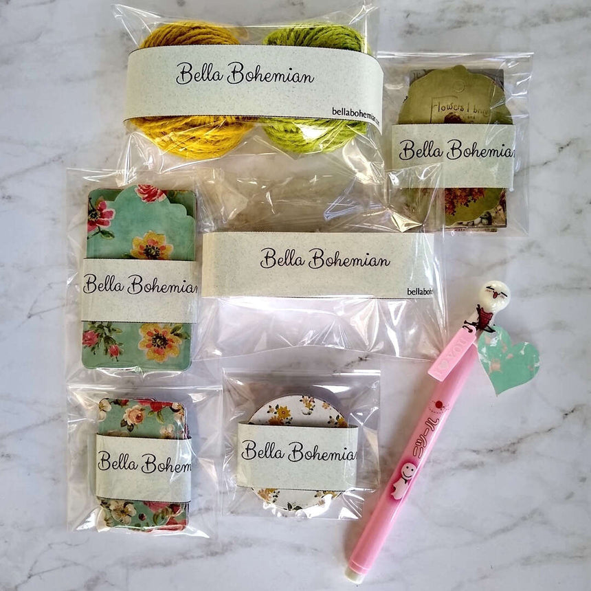 gift tags, hemp string, ribbon and Japanese pen laid out flat all plastic wrapped