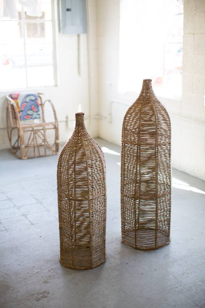 two large decorative bottles made of seagrass and iron