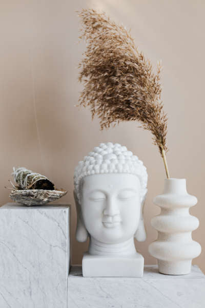 a decorative example showing a sage bundle, a buddha head and a vase holding a reed