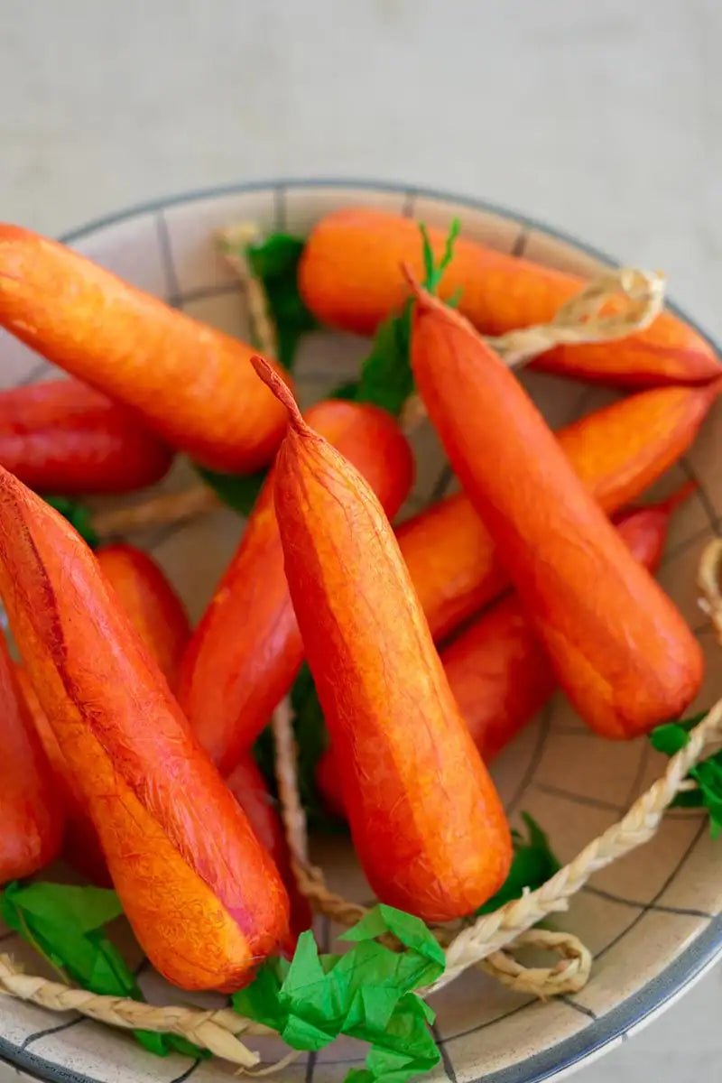 string of faux carrots - in a bowl close-up