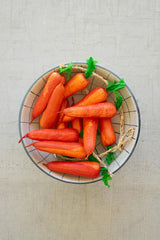 string of faux carrots - shown in a bowl