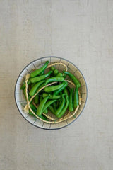 string of green faux peppers - shown in a bowl