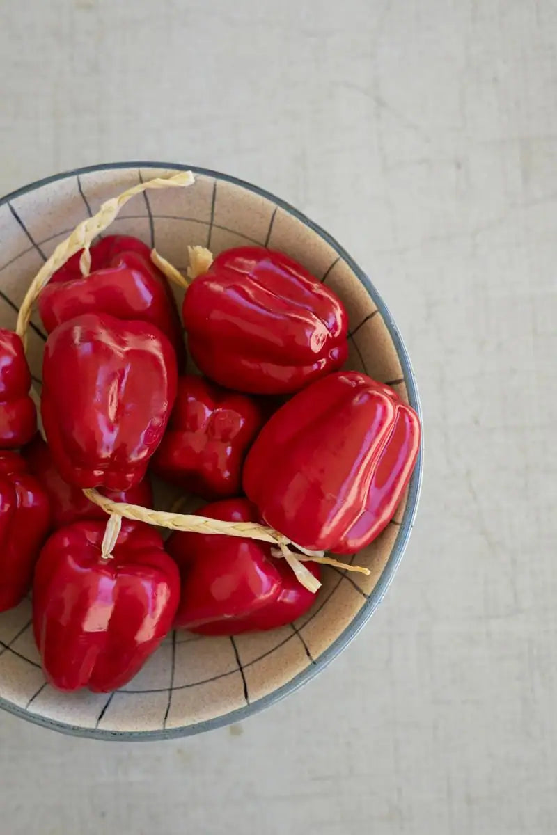 string of red faux bell peppers - shown in a bowl close-up