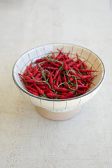 string of red faux peppers - shown in a bowl