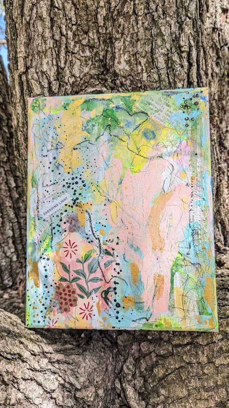 Colorful abstract painting on a textured surface against a tree bark background