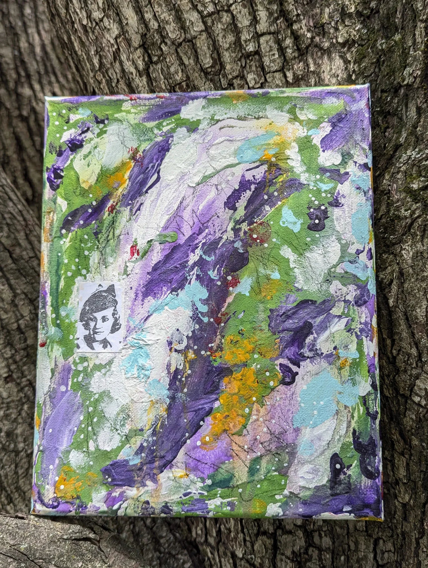 Original colorful abstract painting on a textured surface shown propped up on a tree as background
