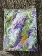 Original colorful abstract painting on a textured surface shown propped up on a tree as background