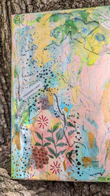Colorful floral abstract painting against a wooden surface