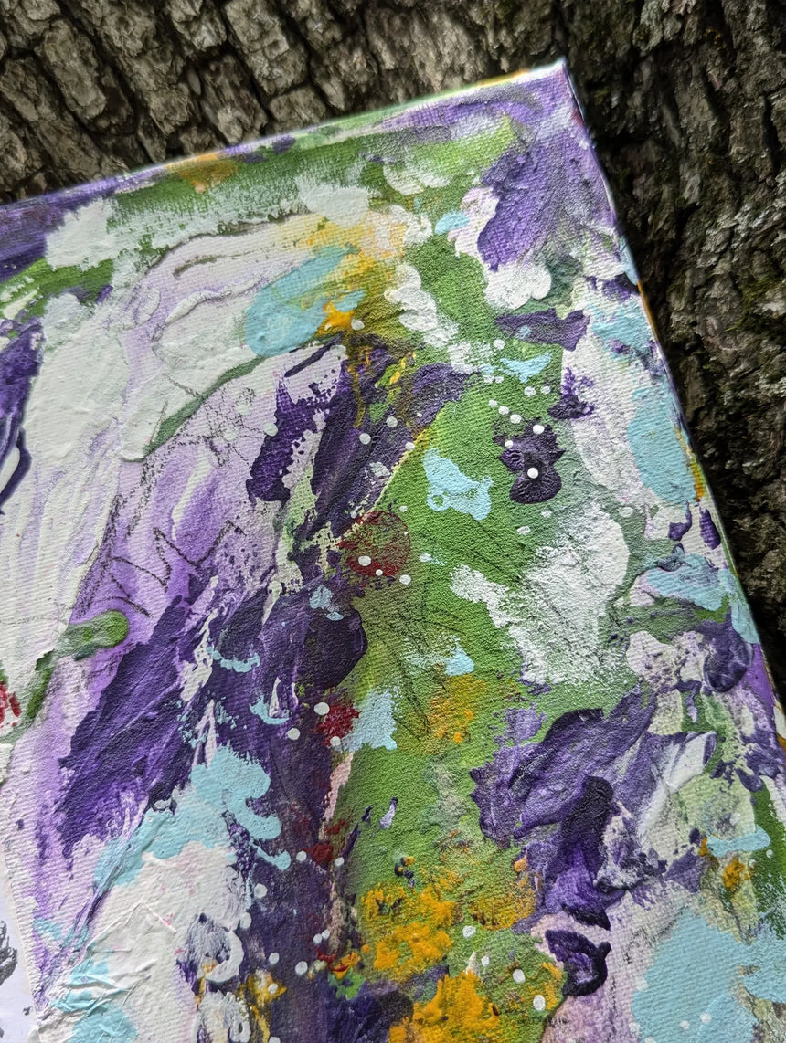Colorful abstract painting on a textured surface against a tree bark background while zooming in on top right details