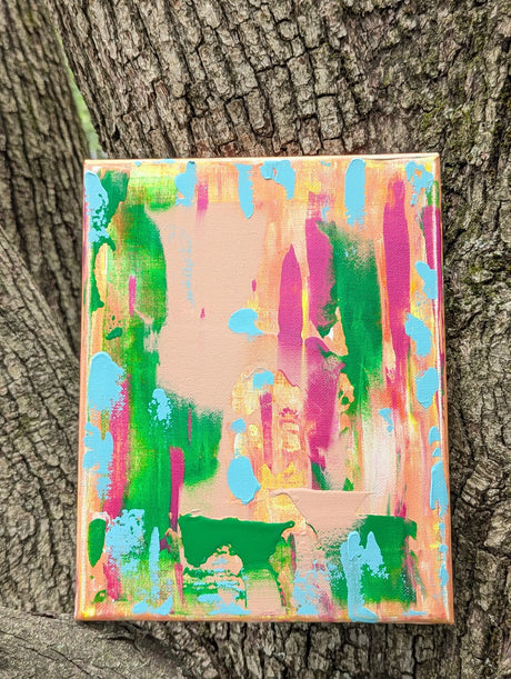 Colorful abstract painting against a tree trunk background