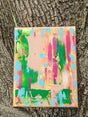 Colorful abstract painting against a tree trunk background