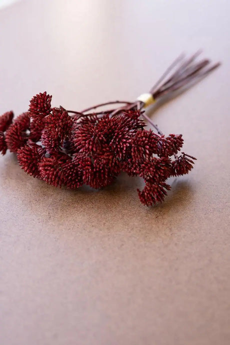 bundles of rust colored faux mini flowers - close-up