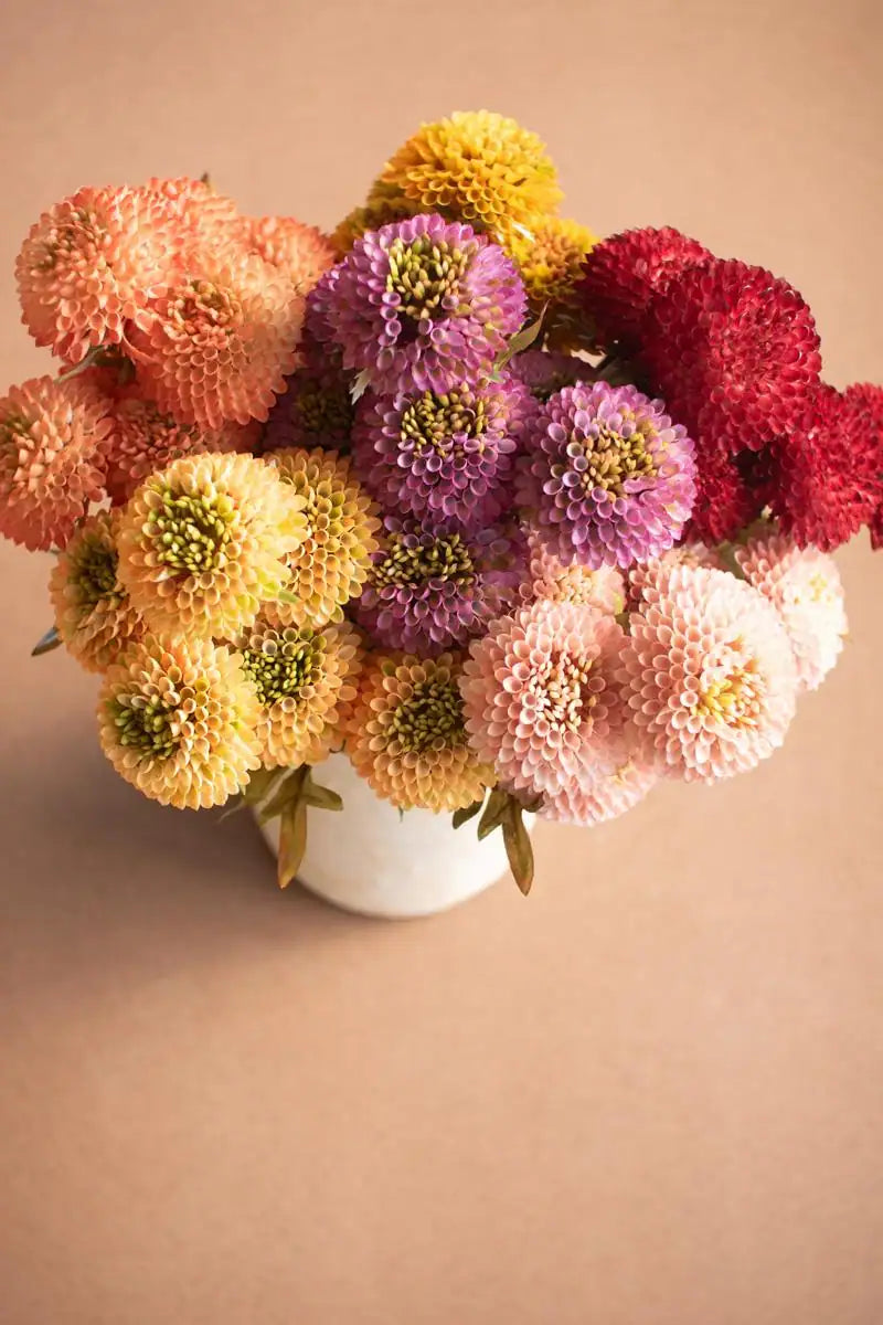 bundles of yellow faux zinnias - shown with many other colors