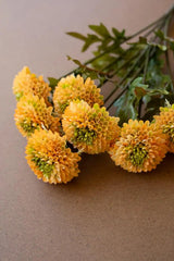 bundles of yellow faux zinnias - angled close-up