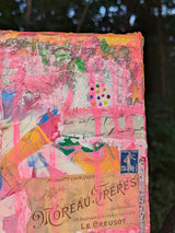 Colorful abstract painting leaning against a tree