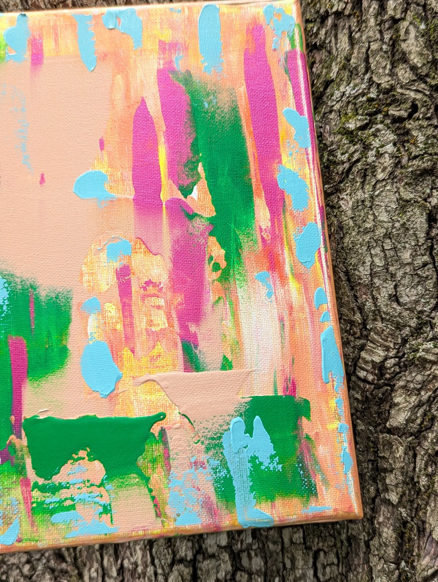 Colorful abstract painting against a tree trunk background with focus on lower right corner