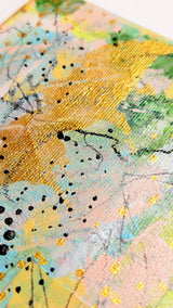 Close-up of a textured surface with abstract patterns in yellow, green and blue.