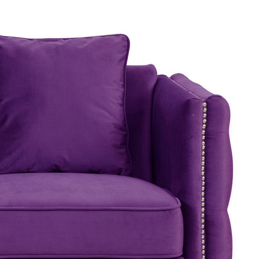 close-up of purple sofa's arm rest and pillow