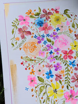 A close-up of a watercolor floral painting featuring a dense arrangement of multicolored flowers and green leaves on a white background, with a gold textured vertical stripe on the left side.