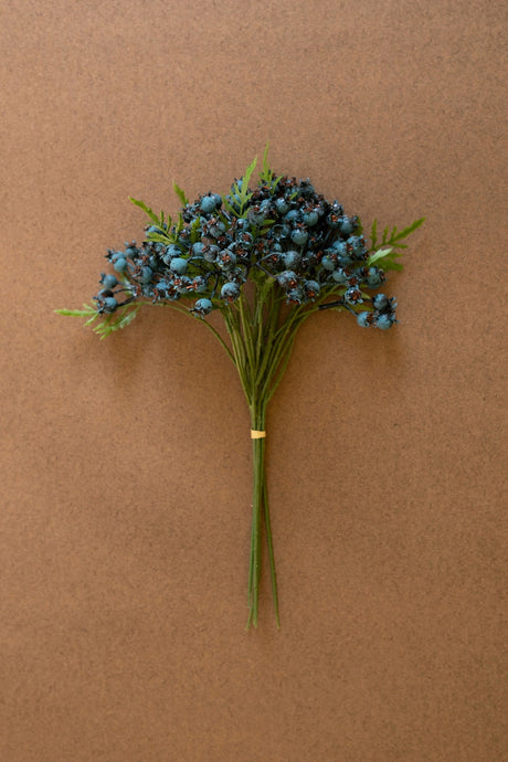 Bouquet of blue flowers with green stems on a brown background