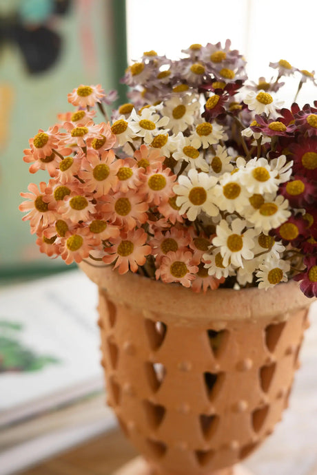 Decorative vase with a mix of flowers on a surface
