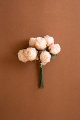 Bouquet of faux pink roses on a brown background