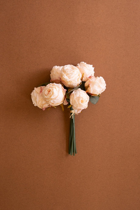 Bouquet of faux pink roses on a brown background