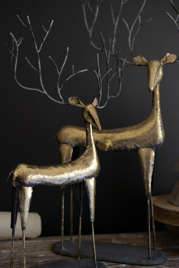 set of 2 antique gold reindeer standing on mantle - close-up view focused only on deer