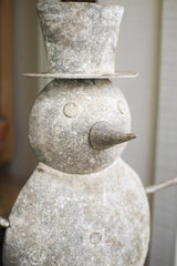 close-up of metal snowman's face and top hat