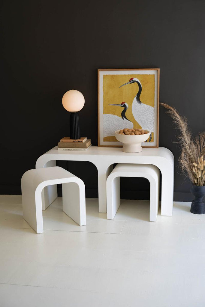 white wood coffee table with 2 smaller nested curved coffee tables with one extruded and standing at an angle