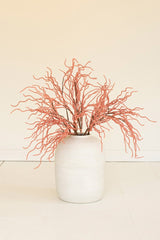 White vase with pink dried branches on a beige background