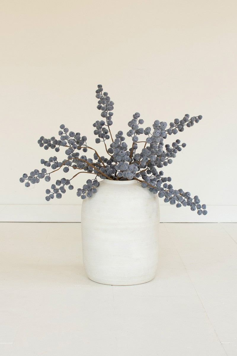 White vase with dried gray branches on a white background