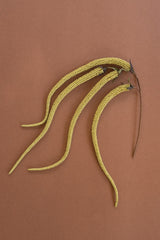 Yellow faux amaranthus plant stems against a brown background
